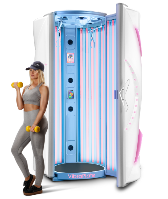 An Ultrasun i8 tanning booth featuring a "VibraPlate" vibrating floor base. The interior is lit with UV and CollaTan lamps. A woman in fitness apparel stands to the side holding two yellow dumbbells, emphasizing the unit's dual use for tanning and exercise recovery.
