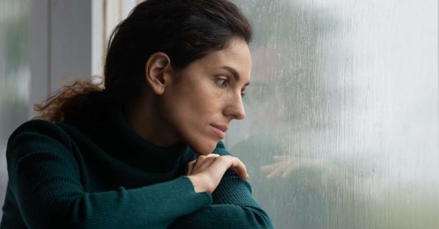 woman looking outside of a window