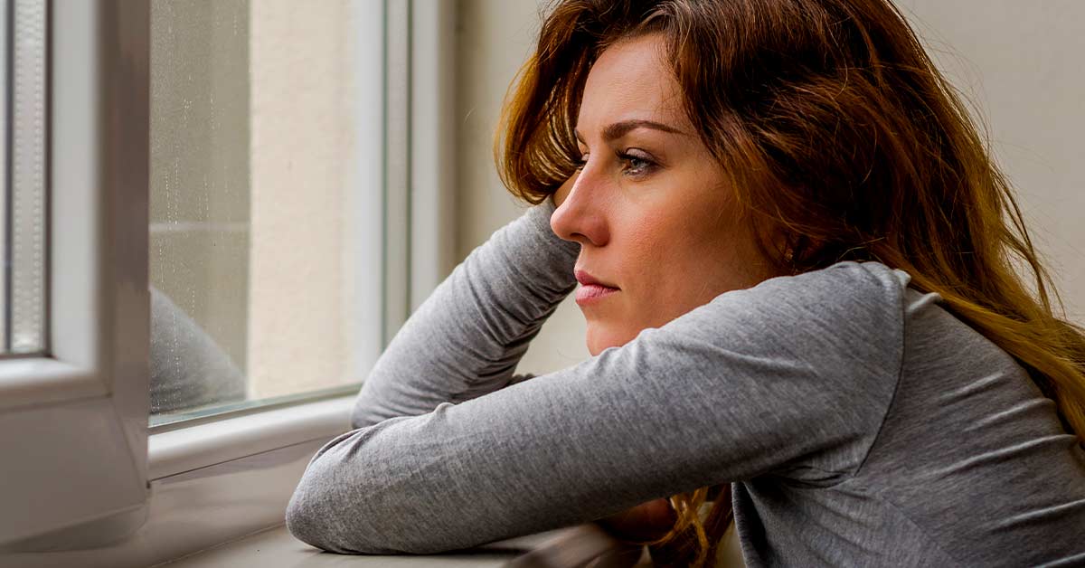 woman looking outside of a window