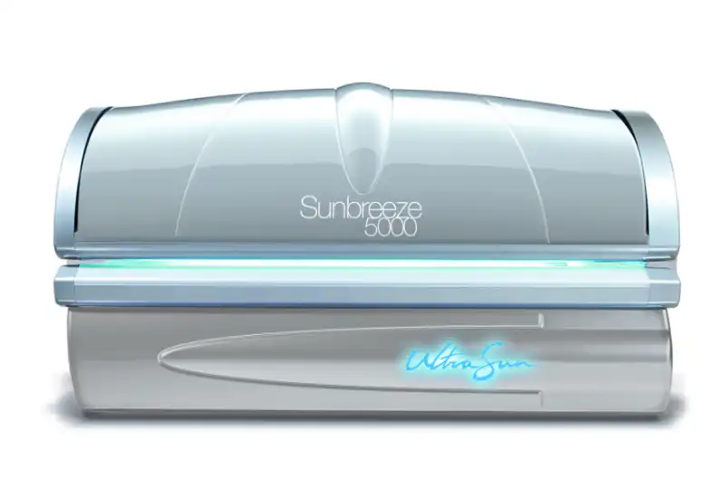A closed, silver lie-down Ultrasun Sunbreeze 5000 tanning bed featuring a glowing blue Ultrasun logo on its base.