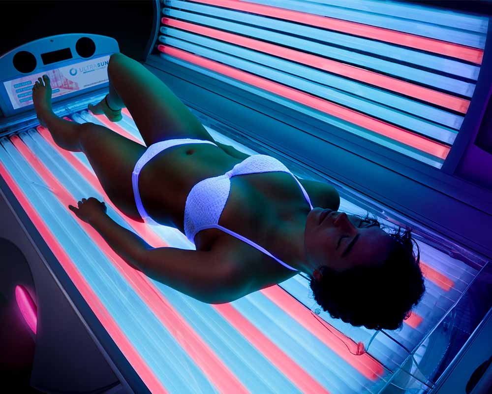 woman inside an Ultrasun Q18 Hybrid tanning bed